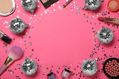 Photo of Frame of shiny disco balls and cosmetic products on pink background, flat lay. Space for text