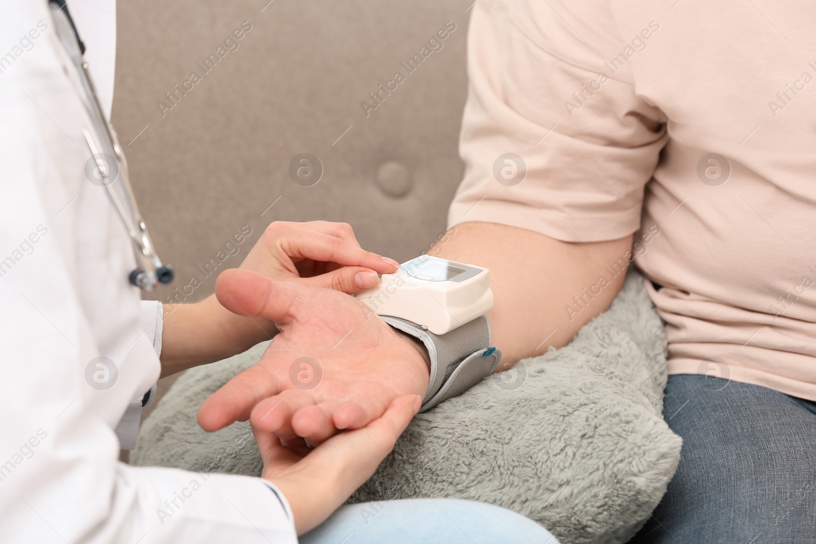 Photo of Nurse measuring blood pressure of elderly man against grey background, closeup. Assisting senior generation