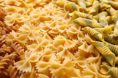 Photo of Different types of pasta as background, closeup