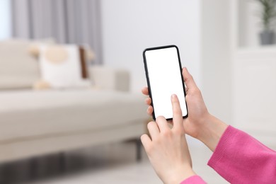Photo of Woman using mobile phone indoors, closeup. Space for text