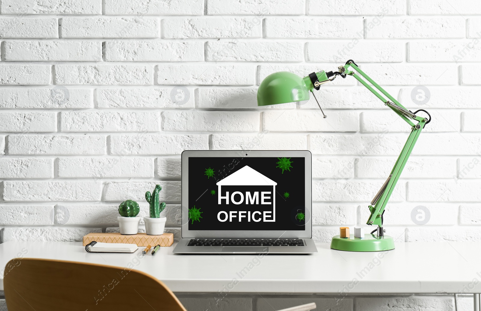 Image of Modern laptop with text HOME OFFICE on white table indoors