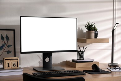 Photo of Stylish workplace with modern computer near white wall indoors. Space for text