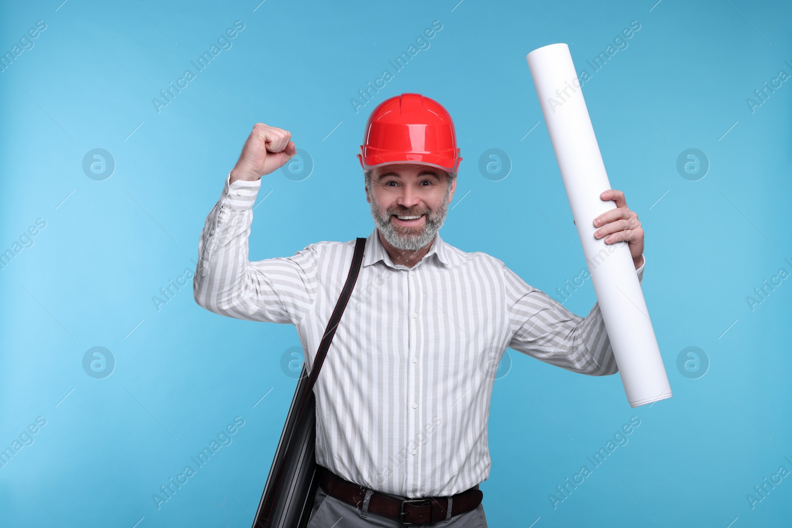 Photo of Architect in hard hat holding draft on light blue background