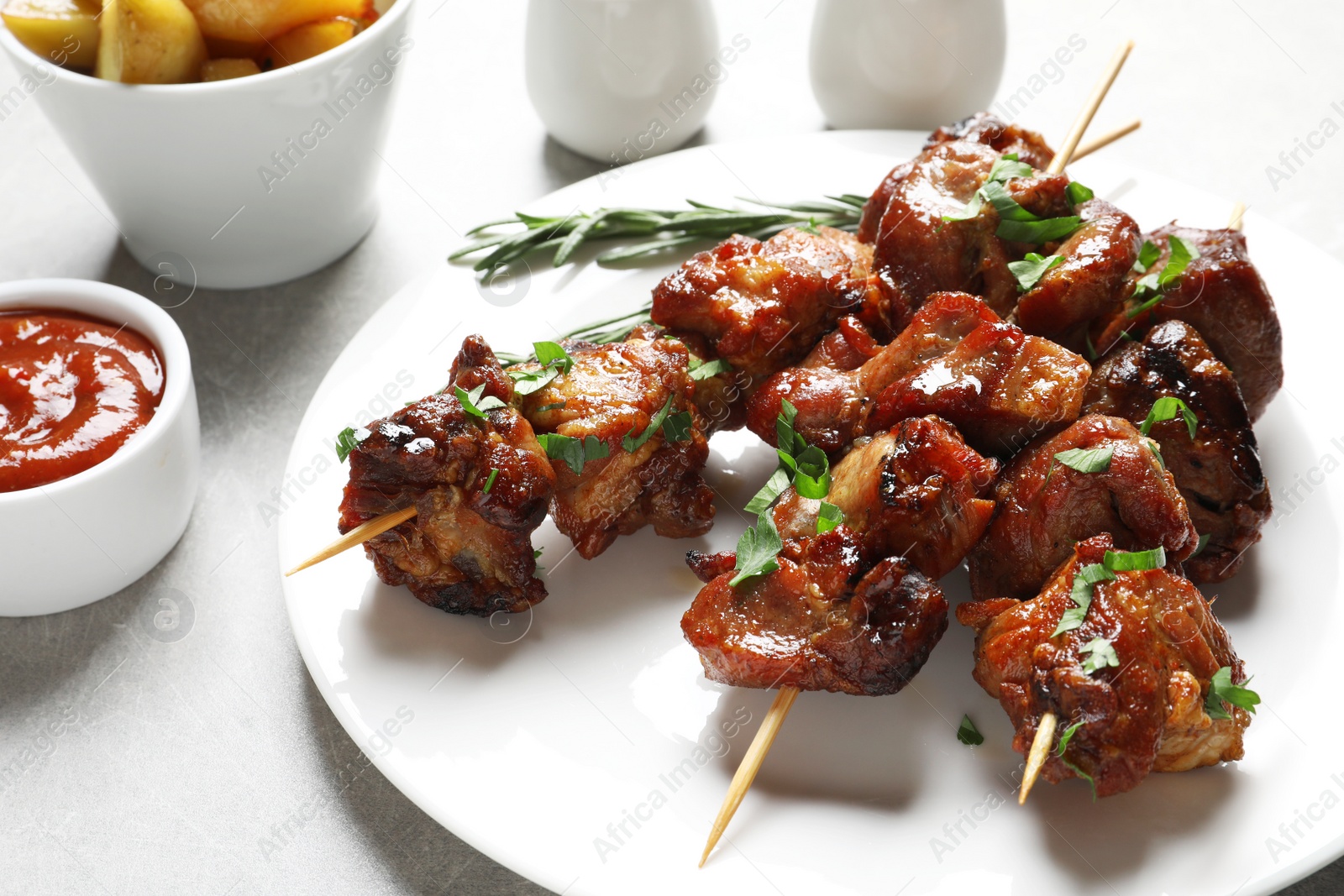 Photo of Plate with delicious meat served for barbecue party on gray table