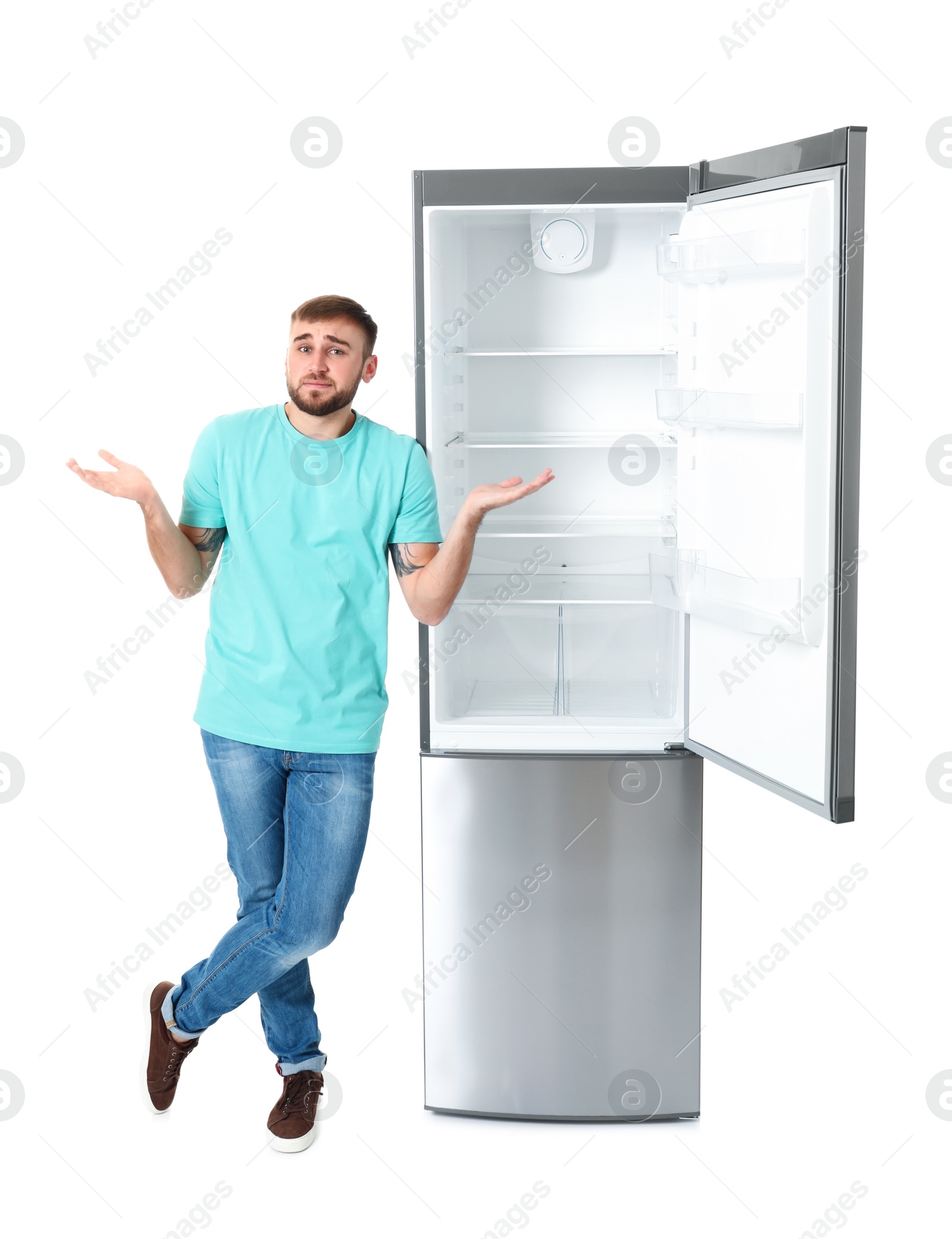 Photo of Emotional man near empty refrigerator on white background