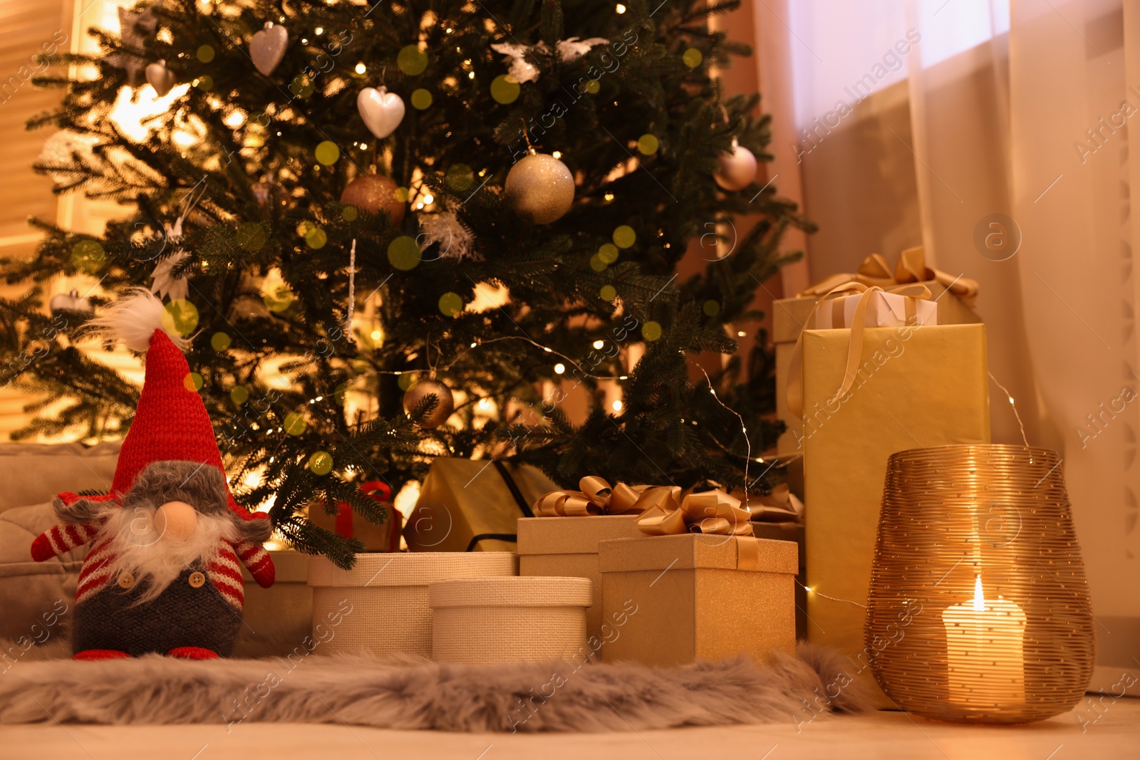 Photo of Christmas tree, gift boxes and gnome indoors