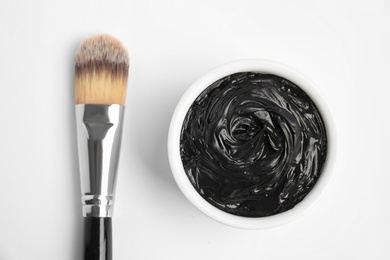 Photo of Professional face mask with brush on white background, top view