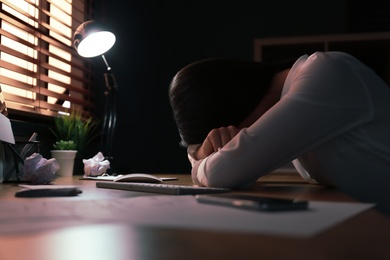 Stressed out businesswoman at workplace late in evening