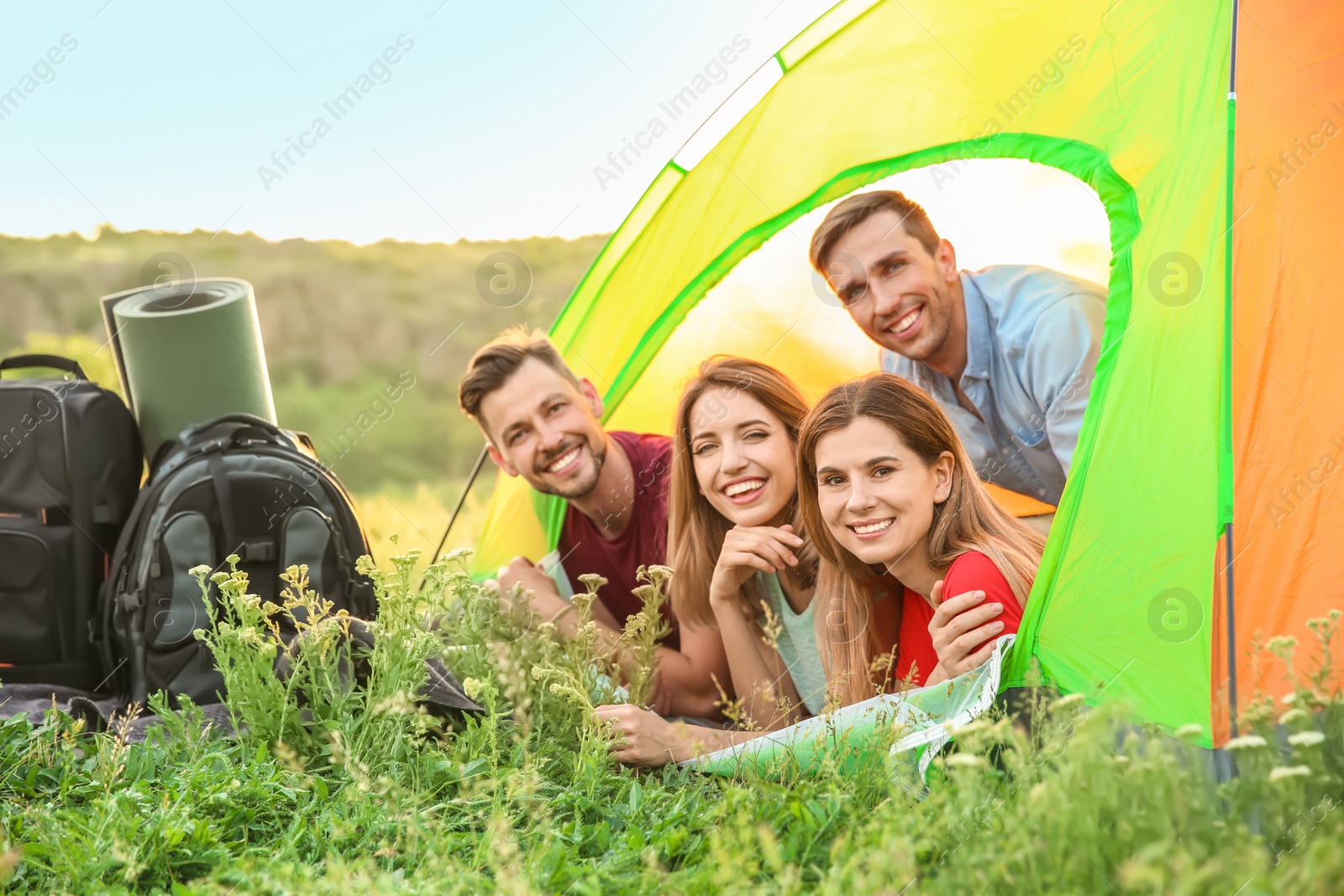 Photo of Group of happy young people in camping tent