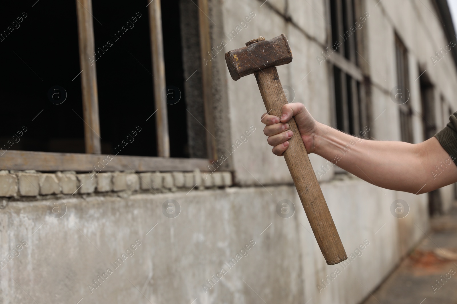 Photo of Man with sledgehammer near old building outdoors, closeup. Space for text