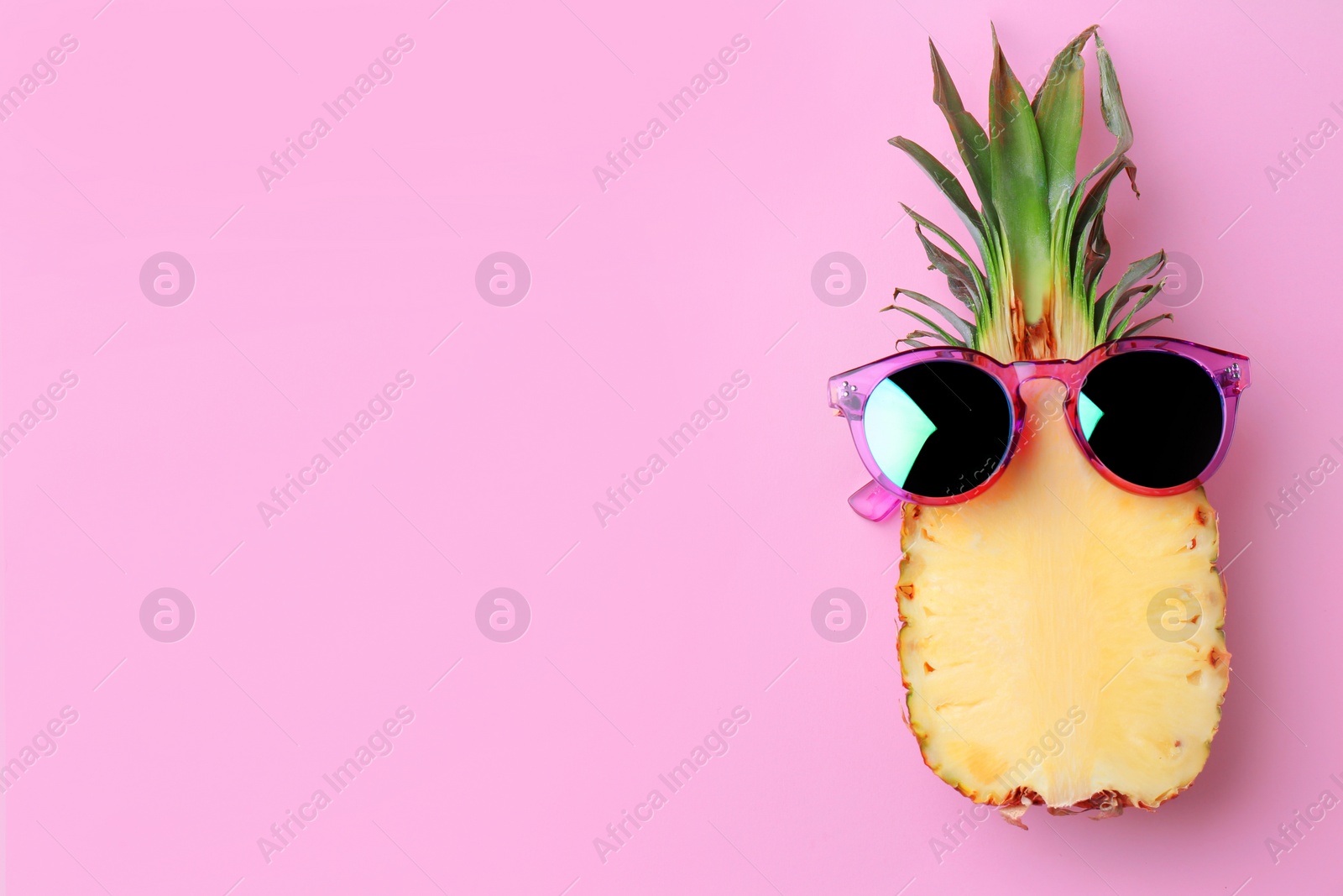 Photo of Funny pineapple with sunglasses on color background