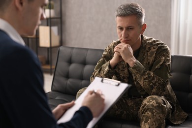 Photo of Professional psychotherapist working with military man in office