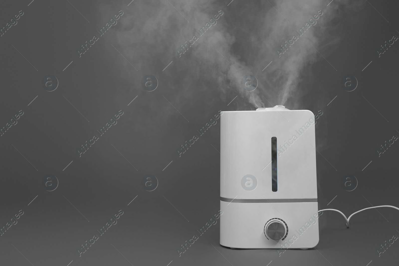 Photo of Modern air humidifier on grey background. Space for text