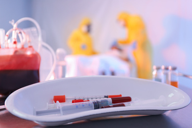 Photo of Medical bowl with samples of virus on table in quarantine ward, closeup
