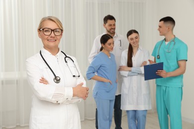 Portrait of doctor near colleagues in clinic