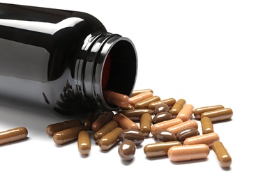 Photo of Bottle with vitamin capsules on white background, closeup