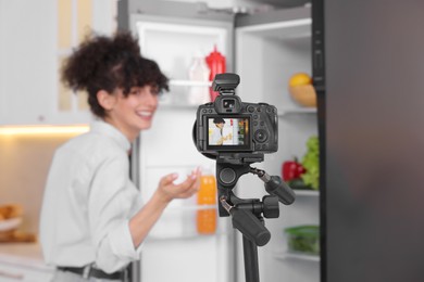 Food blogger recording video in kitchen, focus on camera