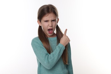 Surprised girl pointing at something on white background