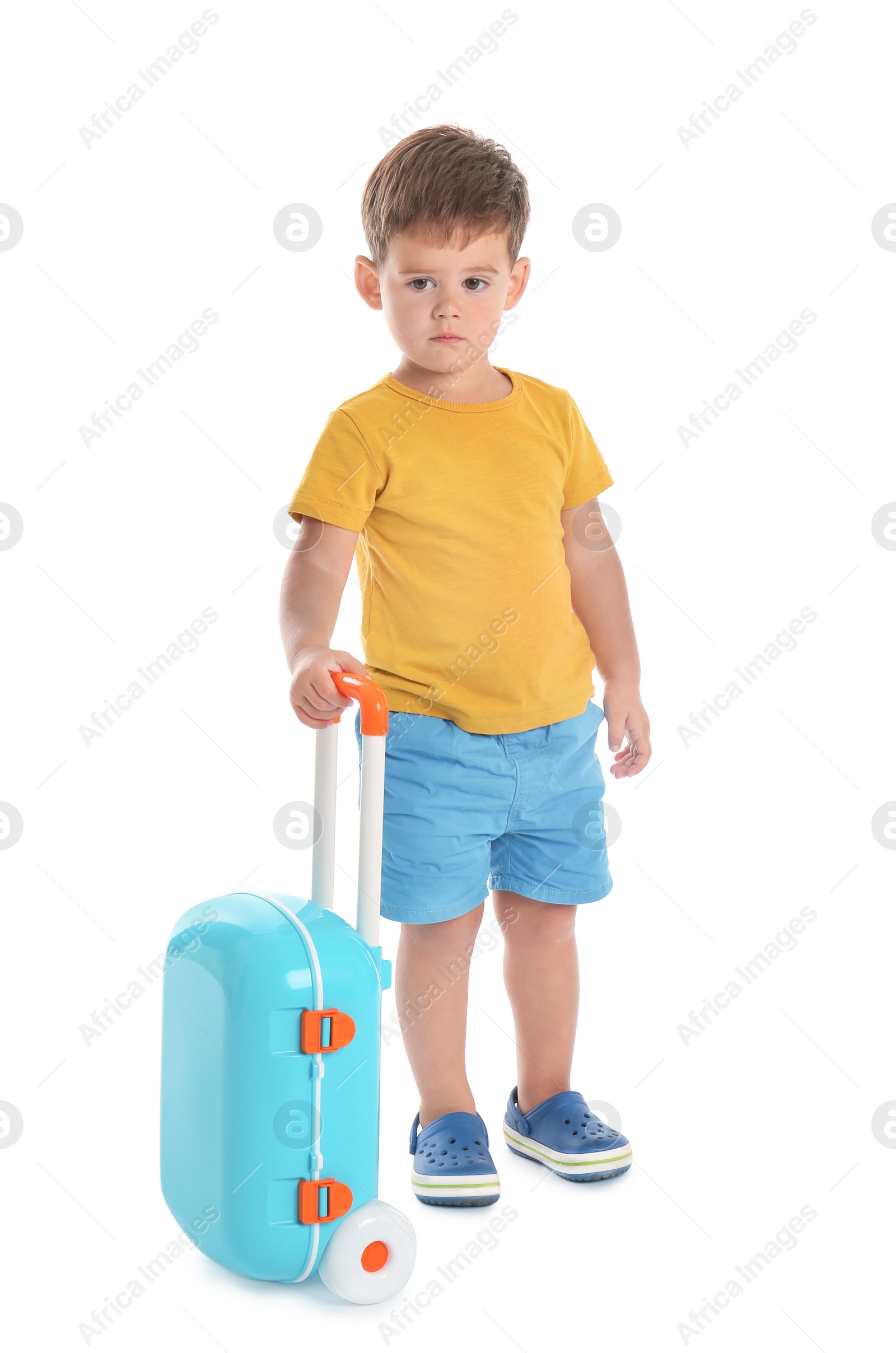 Photo of Cute little boy with blue suitcase on white background