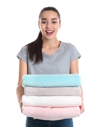 Happy young woman holding clean towels on white background. Laundry day