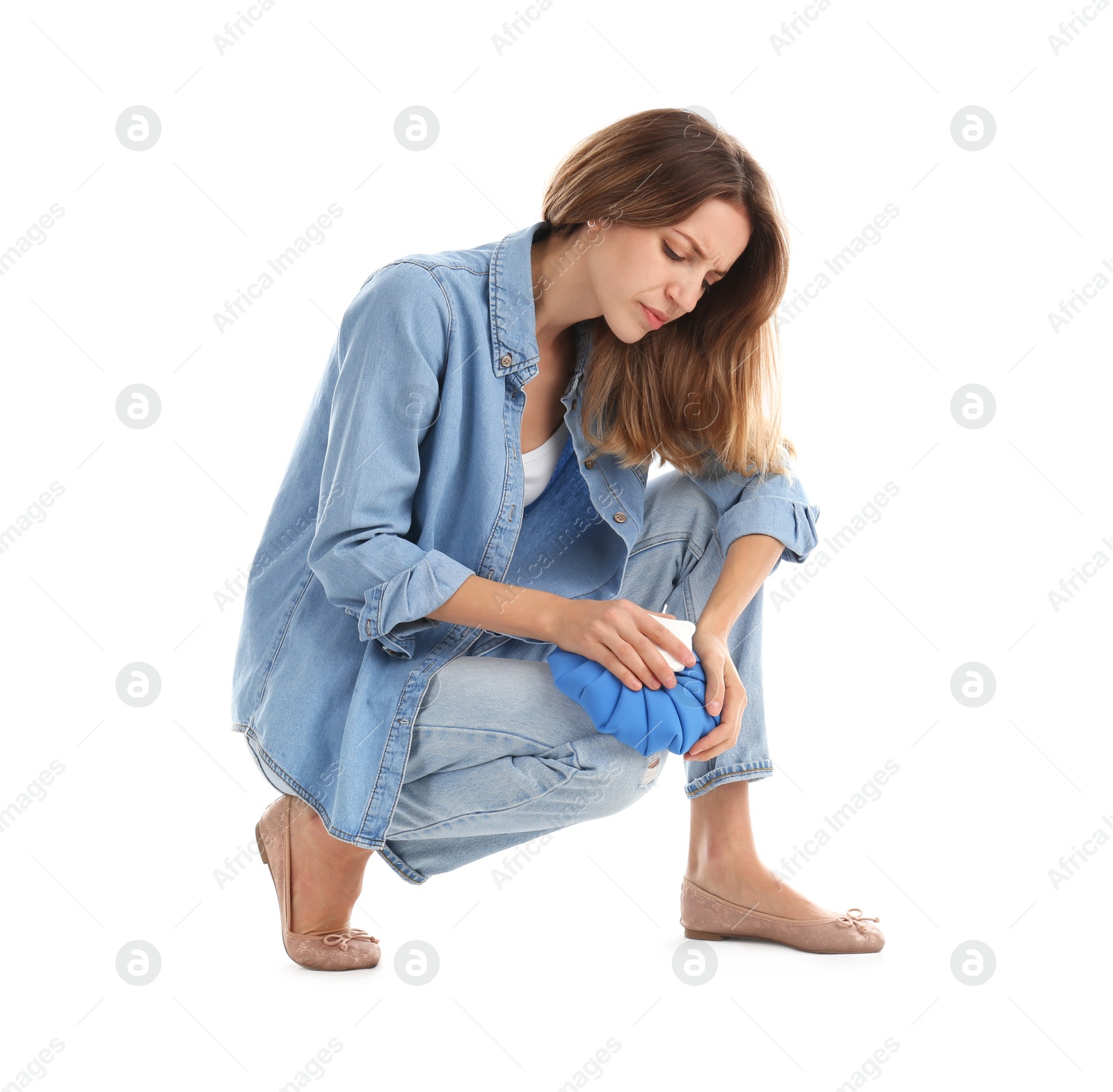 Photo of Woman applying cold compress to relieve knee pain on white background