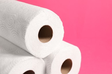 Photo of Many rolls of paper towels on pink background, closeup. Space for text