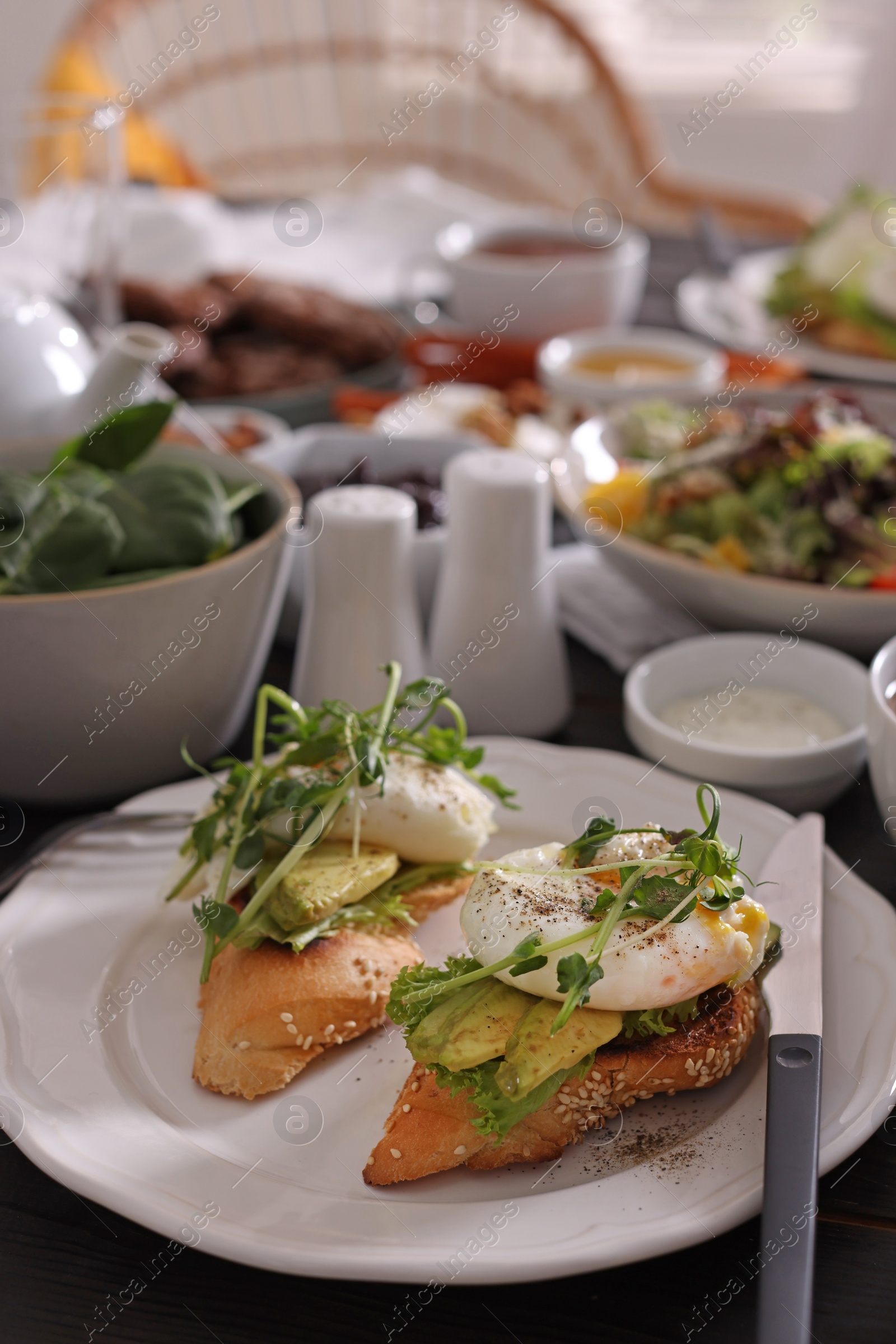 Photo of Delicious sandwiches and many different dishes served on buffet table for brunch