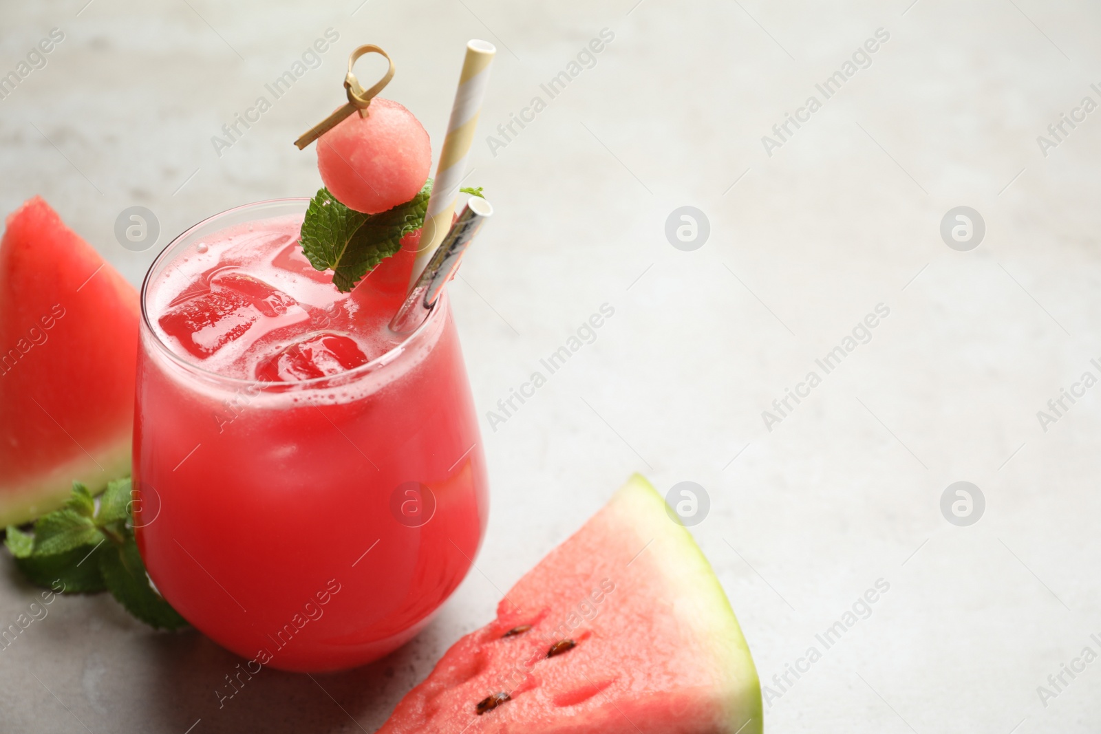 Photo of Delicious fresh watermelon drink on grey table. Space for text