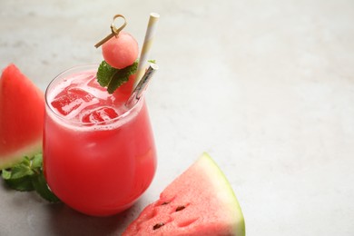 Photo of Delicious fresh watermelon drink on grey table. Space for text