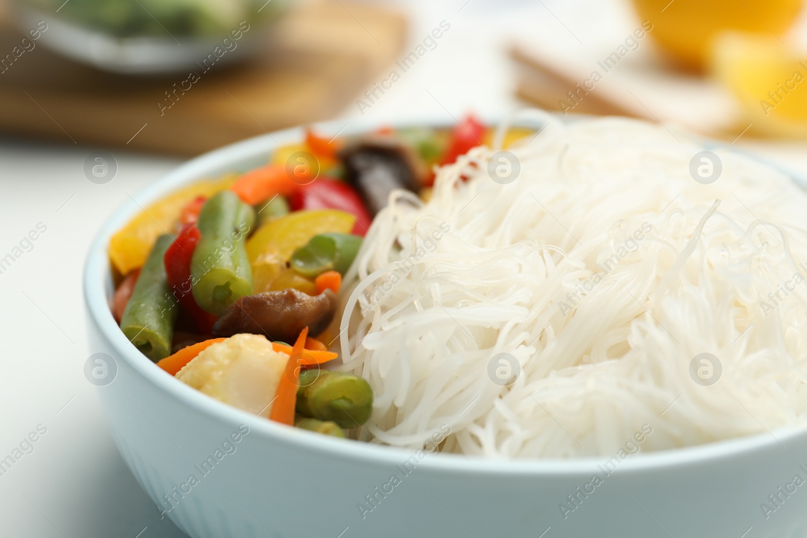 Photo of Tasty cooked rice noodles with vegetables on table, closeup