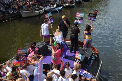 Photo of AMSTERDAM, NETHERLANDS - AUGUST 06, 2022: Many people in boats at LGBT pride parade on river