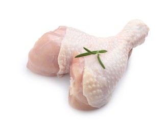 Raw chicken drumsticks with rosemary on white background