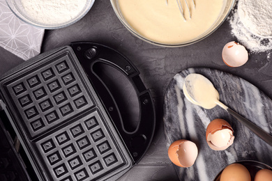 Flat lay composition with ingredients for cooking Belgian waffles on grey table
