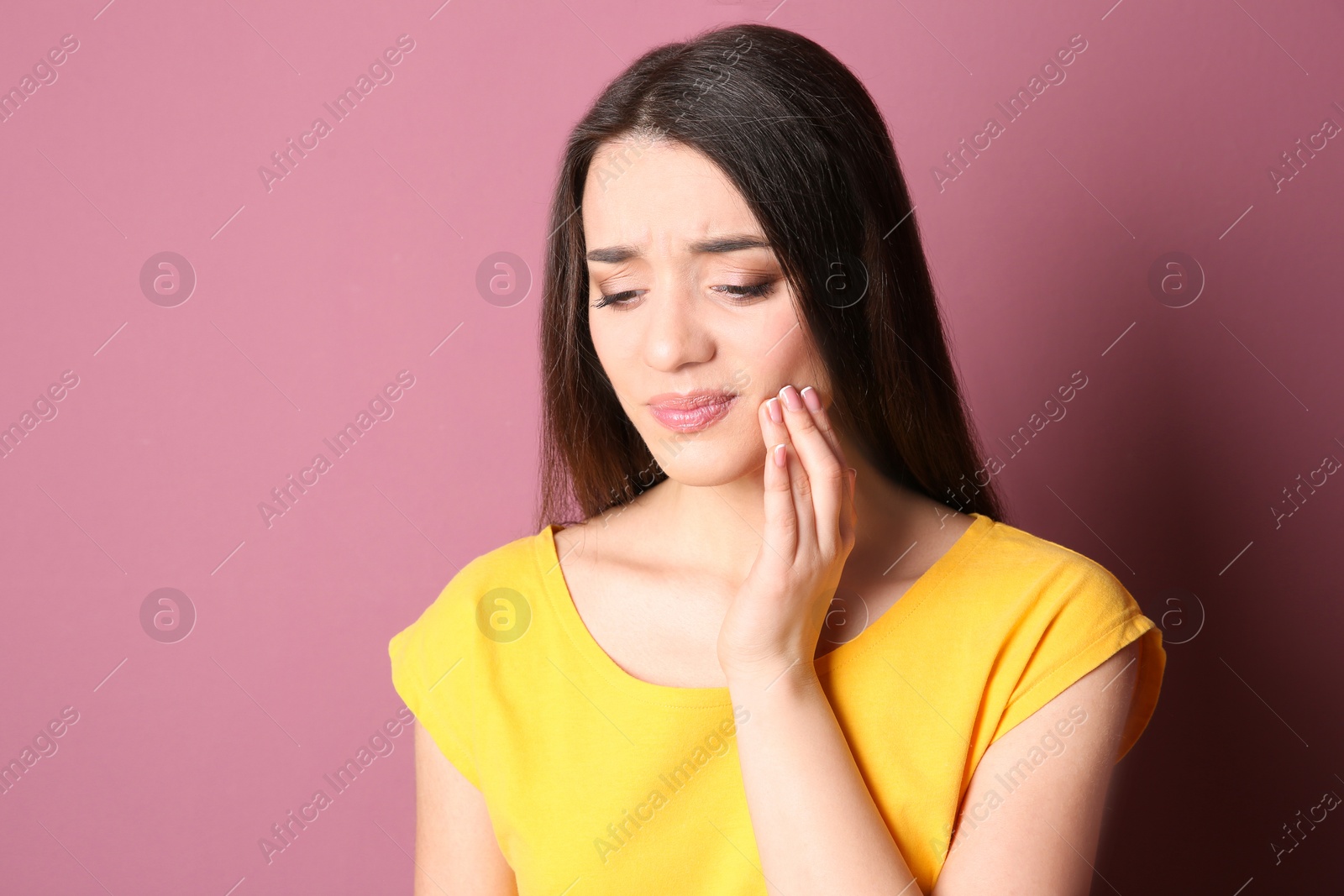 Photo of Woman with sensitive teeth on color background