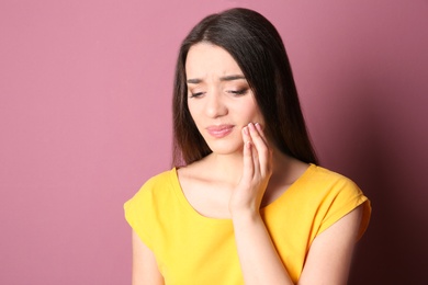 Photo of Woman with sensitive teeth on color background