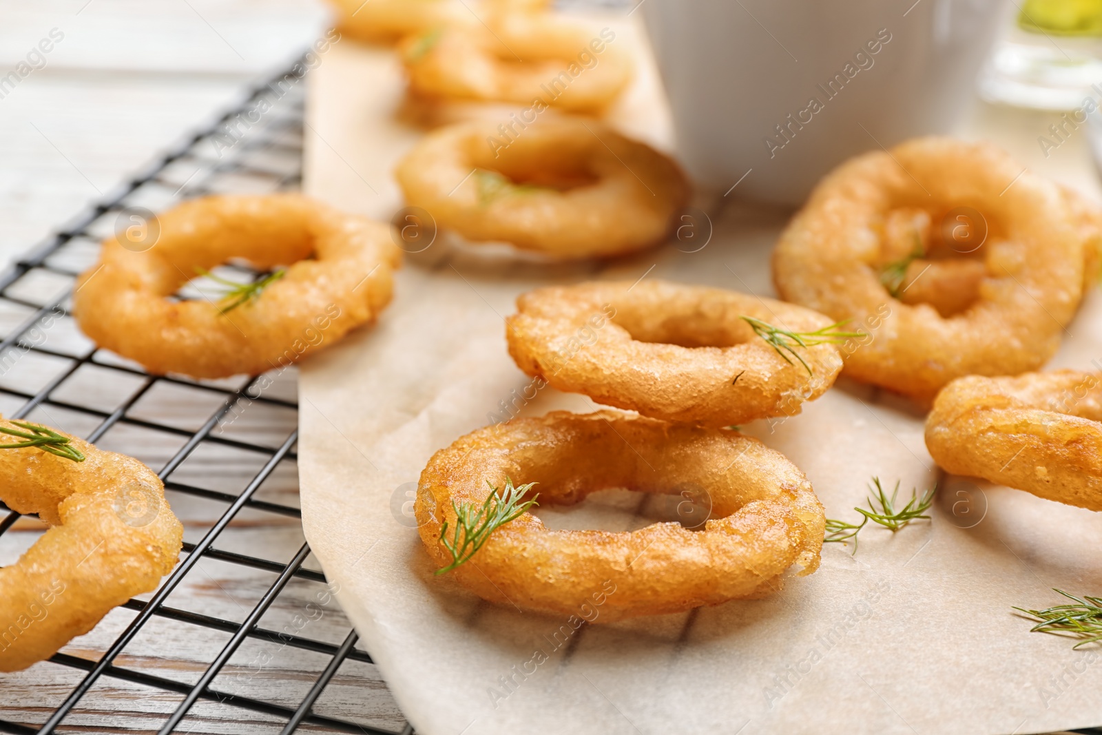 Photo of Fried onion rings on cooling rack, closeup