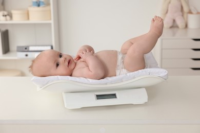 Cute little baby lying on scales in clinic