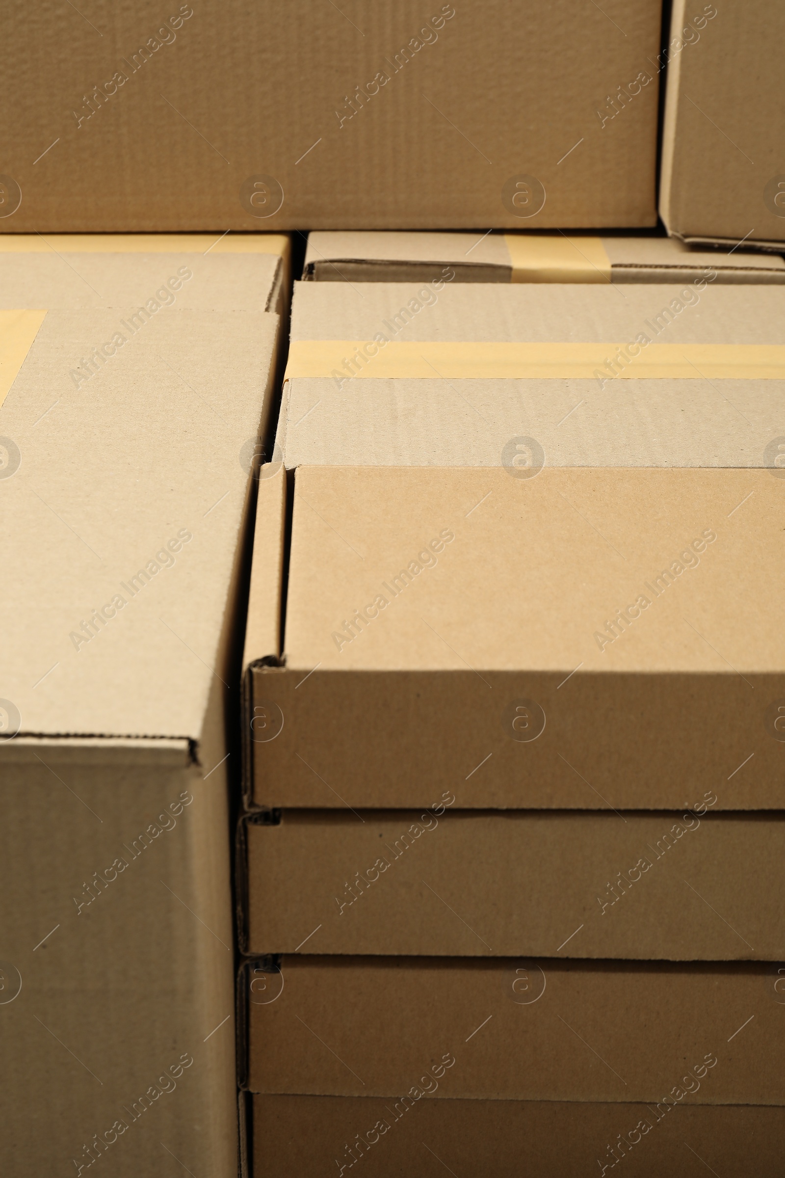 Photo of Many cardboard boxes as background, closeup. Packaging goods