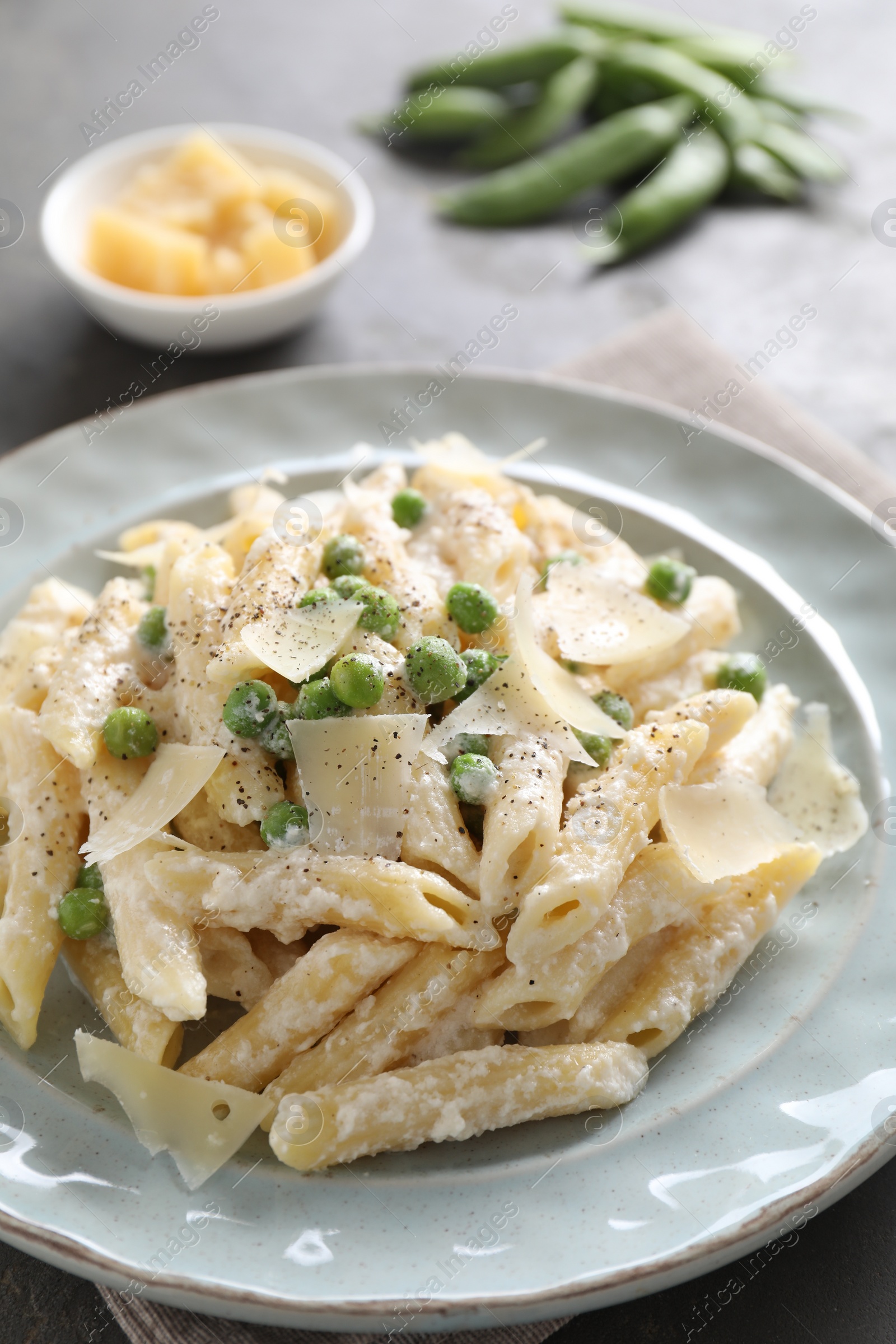 Photo of Delicious pasta with green peas, cheese and creamy sauce on table