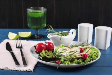 Photo of Tasty mozzarella, chicken and vegetables with tarragon served on blue wooden table