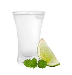 Photo of Shot glass of vodka, mint and lime isolated on white