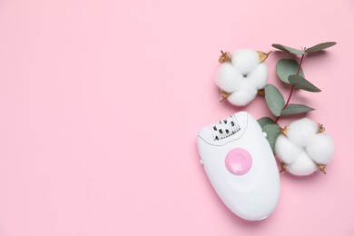 Modern epilator, fluffy cotton flowers and eucalyptus branch on pink background, flat lay. Space for text