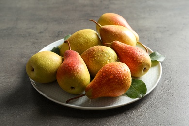 Photo of Plate with ripe pears on grey background