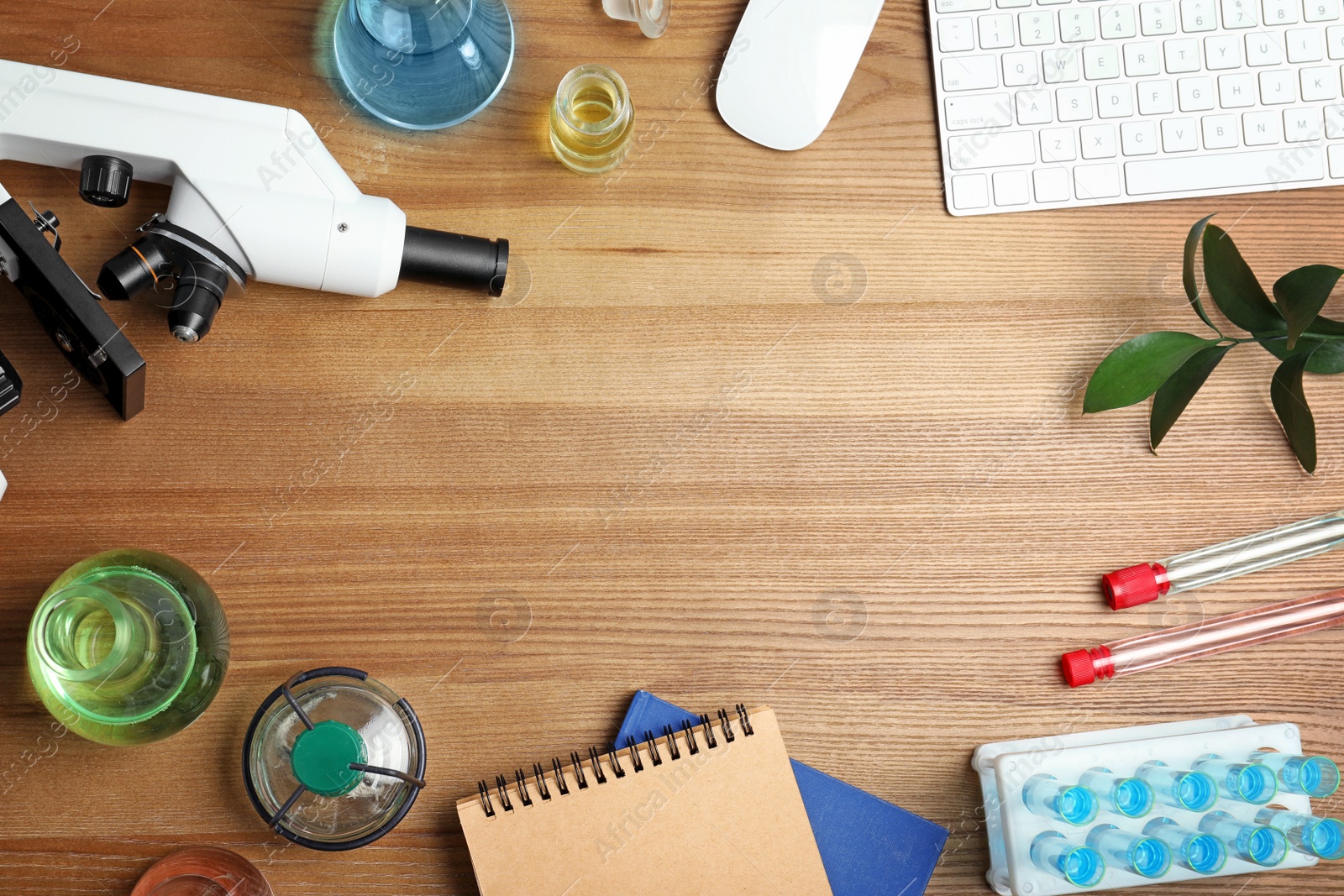 Photo of Flat lay composition with laboratory glassware, microscope and space for text on wooden background. Chemistry concept