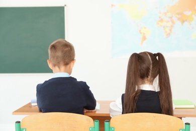 Little children in classroom. Stylish school uniform