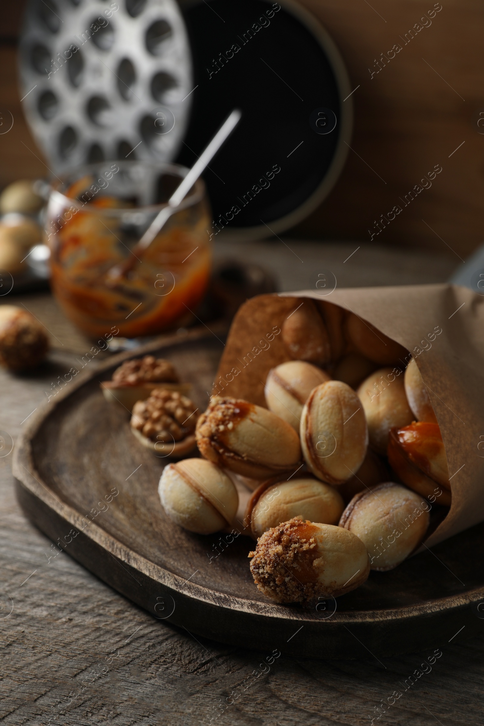 Photo of Freshly baked homemade walnut shaped cookies with condensed milk on wooden table