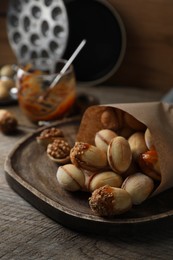 Photo of Freshly baked homemade walnut shaped cookies with condensed milk on wooden table