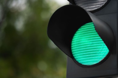 Photo of Closeup view of green traffic light in city. Space for text