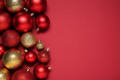 Photo of Christmas balls on red background, top view. Space for text