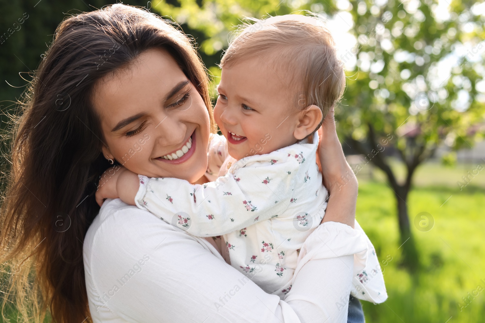 Photo of Happy mother with her cute baby in park on sunny day